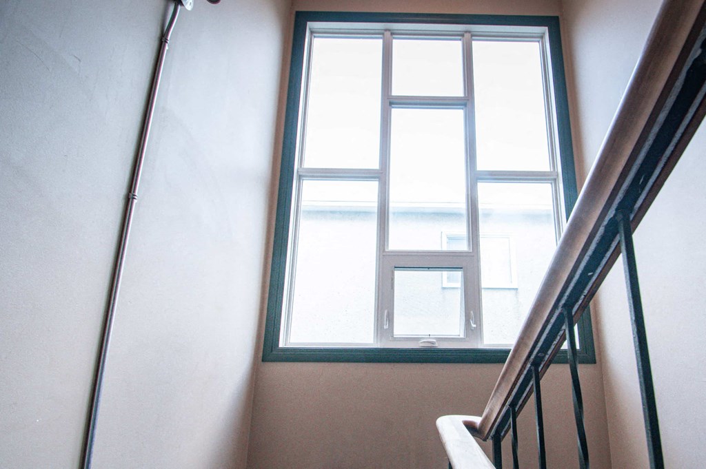 a stairwell with a window and a stair railing