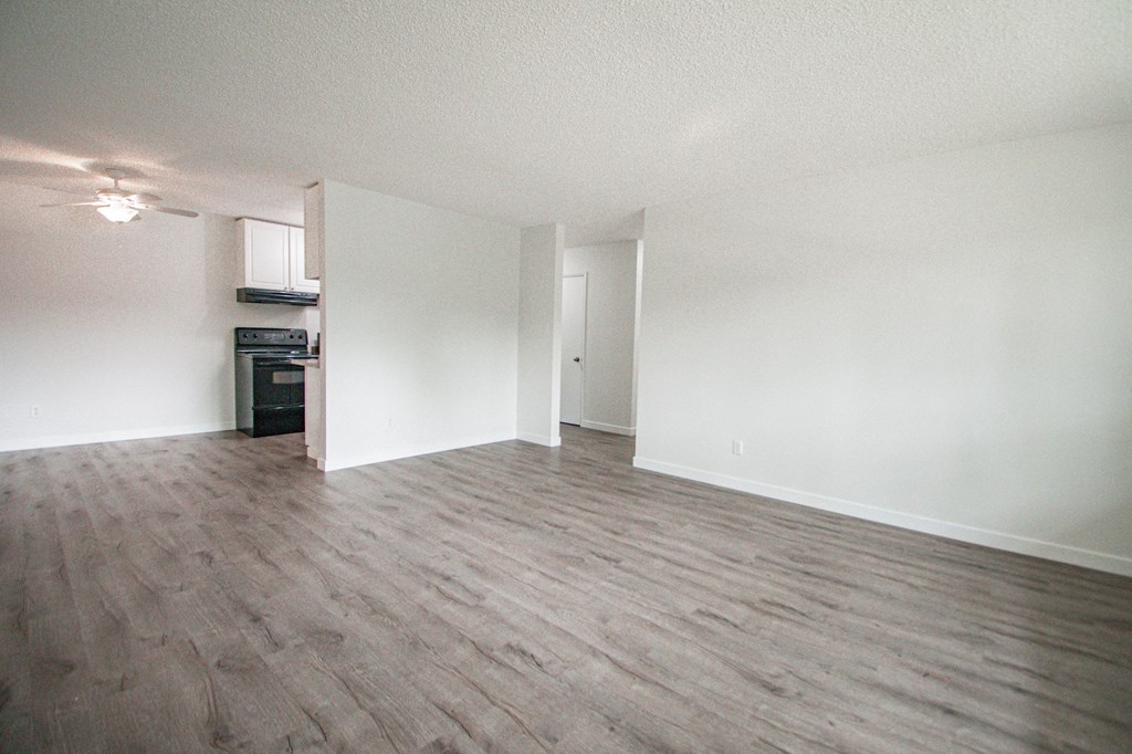 an empty living room with white walls and wood flooring