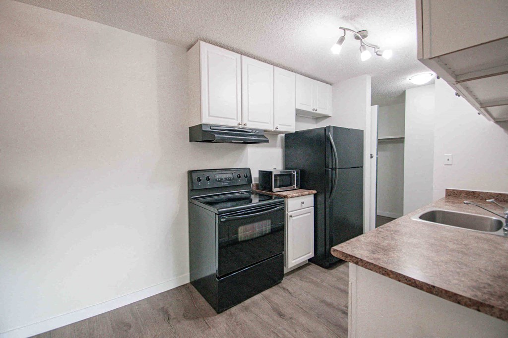 a kitchen with black appliances and white cabinets