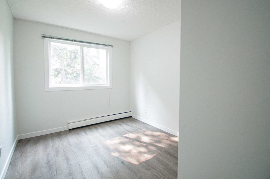 an empty room with white walls and a window