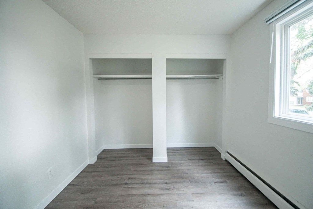 an empty room with white walls and a wood floor