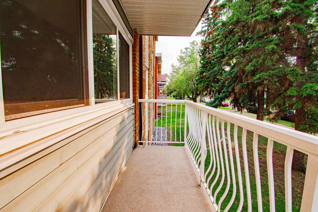 a balcony with a view of a yard and trees