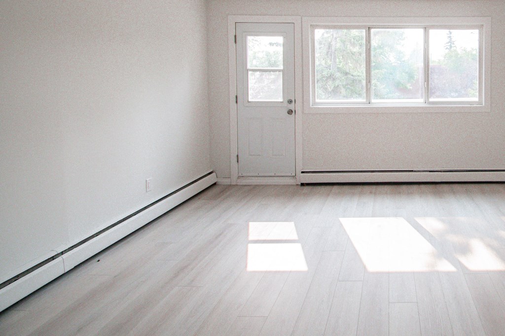 an empty living room with white walls and wooden floors
