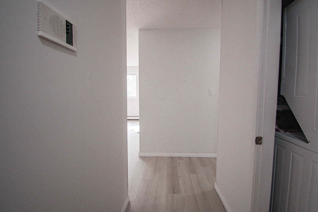 an empty room with a white wall and a door
