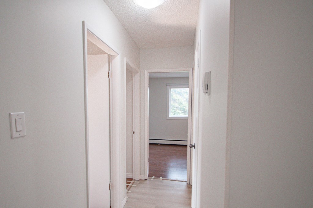 a view of the hallway from the living room to the bedroom with the door open