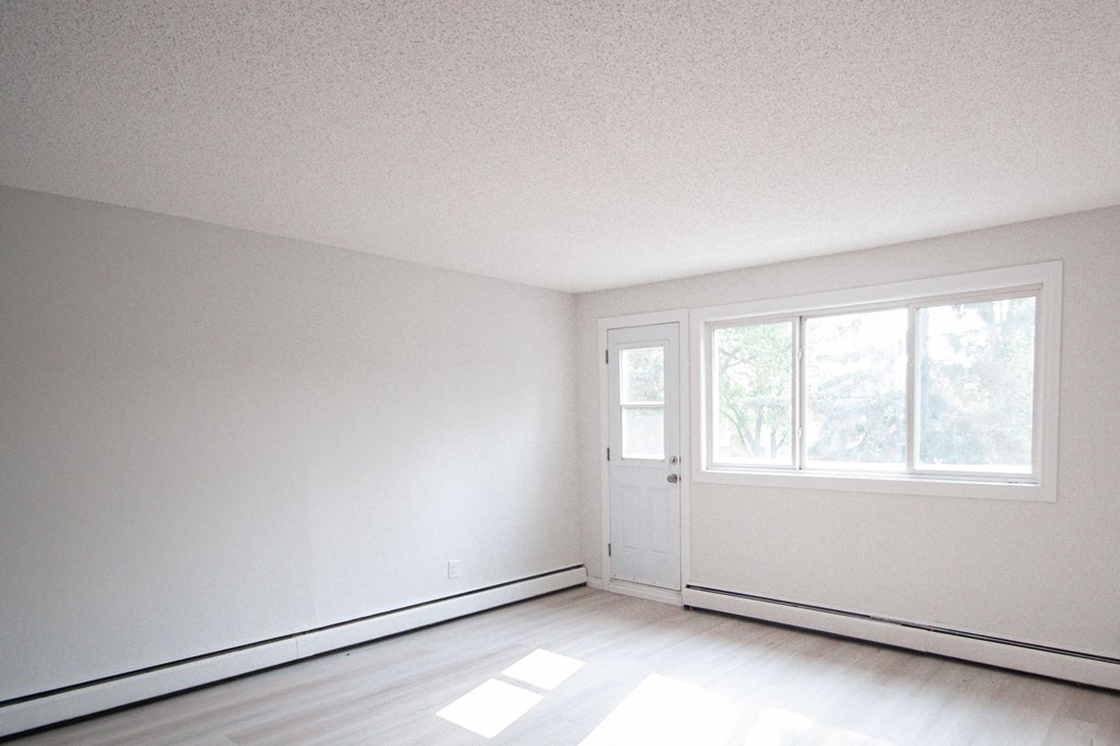 an empty room with white walls and a door and window