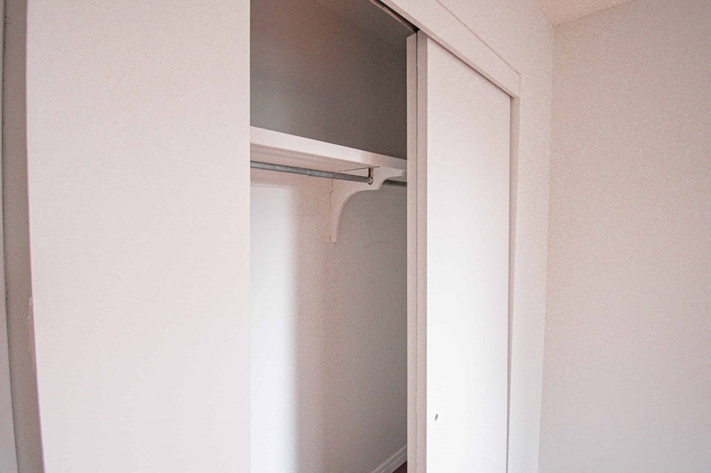a walk in closet with a white door and a mirror above it