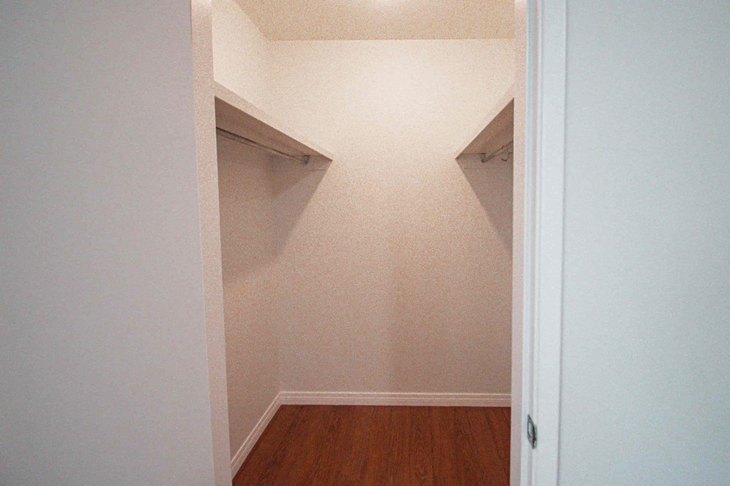 a room with two closets and a hard wood floor