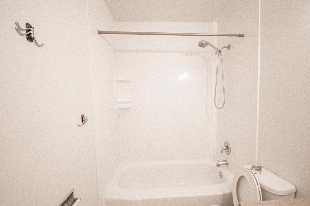 a white bathroom with a shower toilet and sink