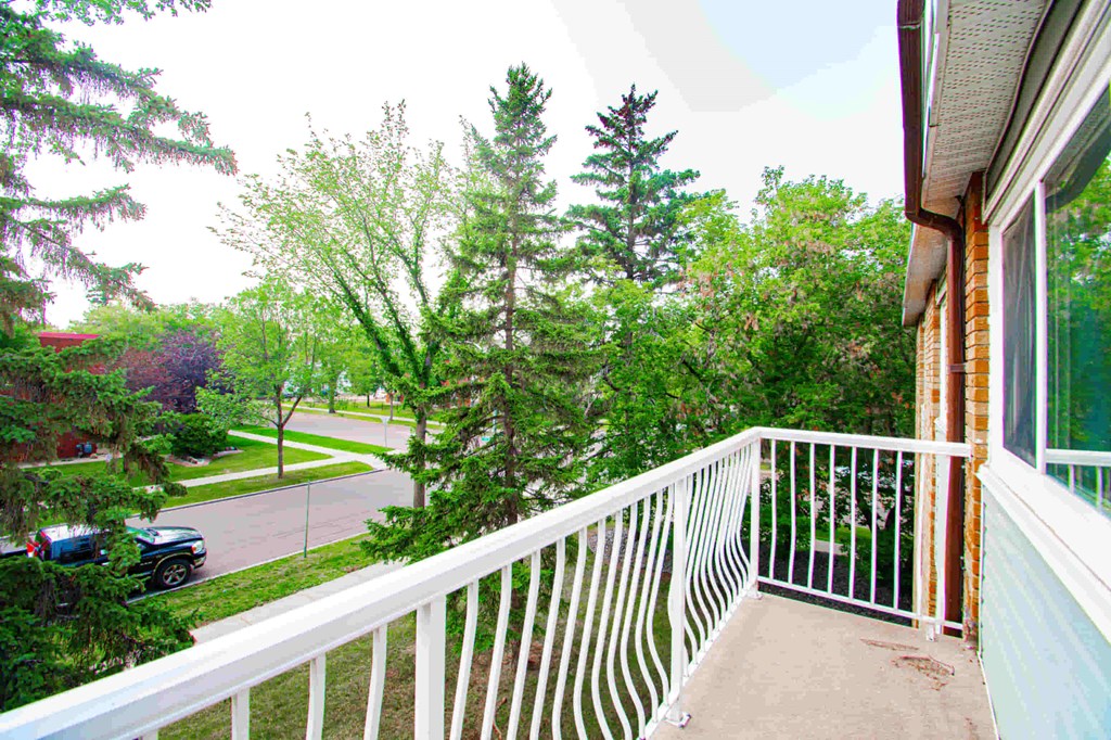 a balcony with a view of a street and trees