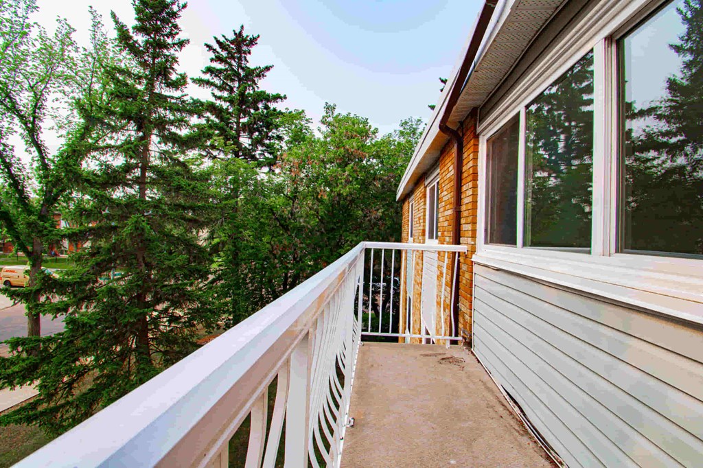a balcony with a view of trees and a house