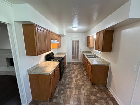 A kitchen with brown cabinets and a checkered floor.