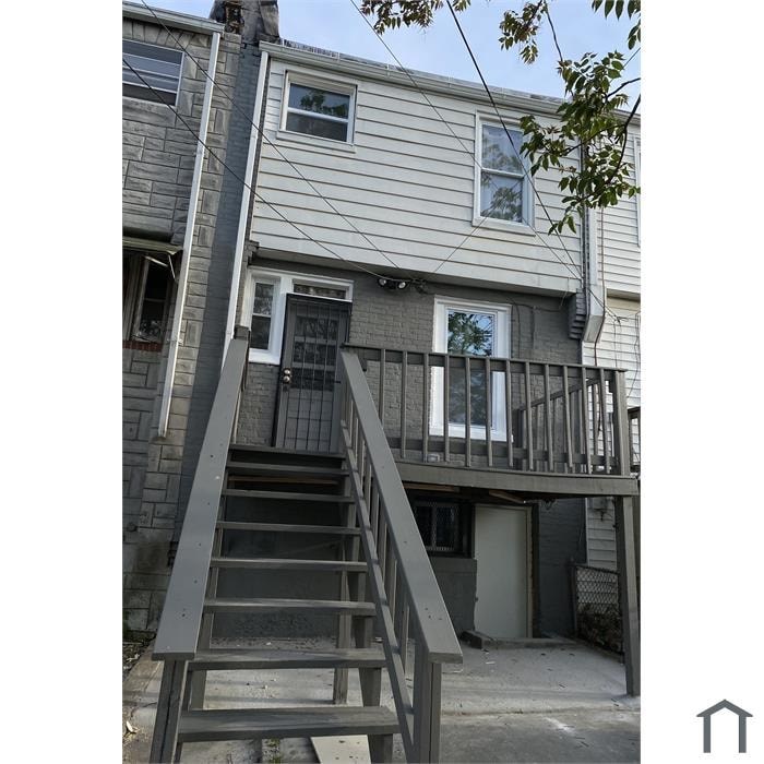 A grey house with a staircase leading to the entrance.