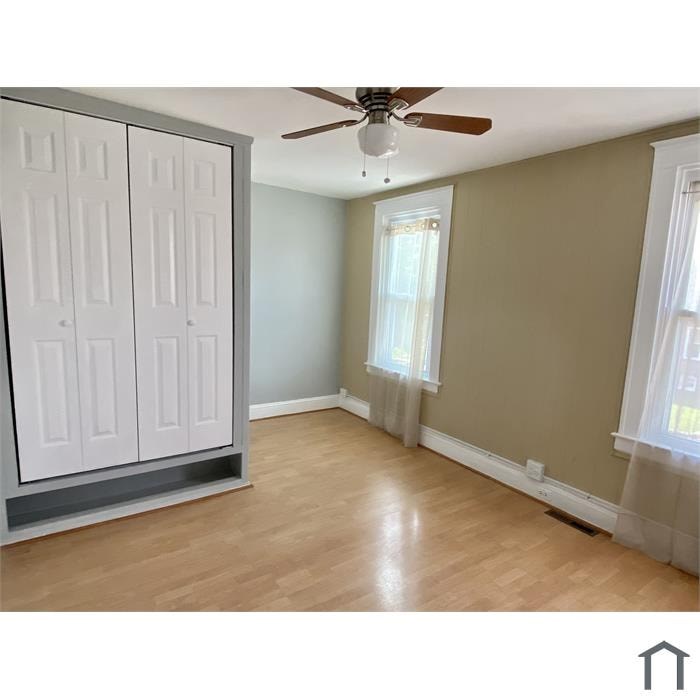 A room with a ceiling fan and a cabinet.