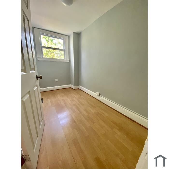 A room with wooden flooring and a window.