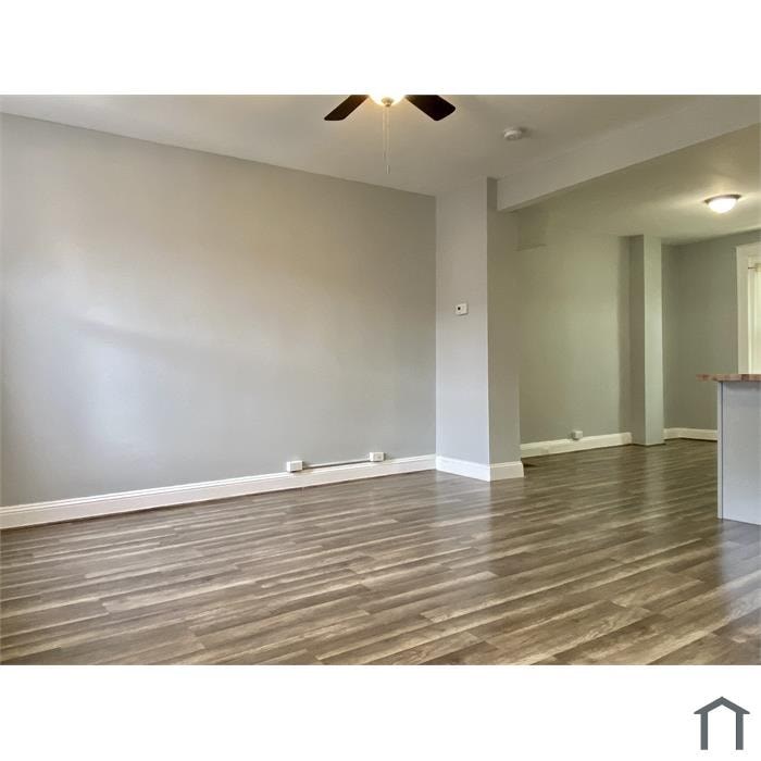 A room with wooden flooring and a ceiling fan.