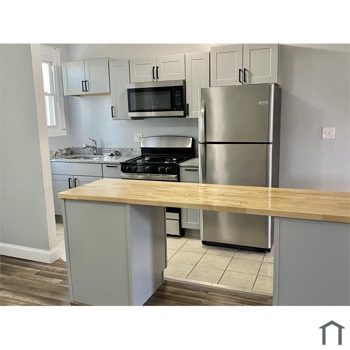 A kitchen with a stove, refrigerator, and cabinets.