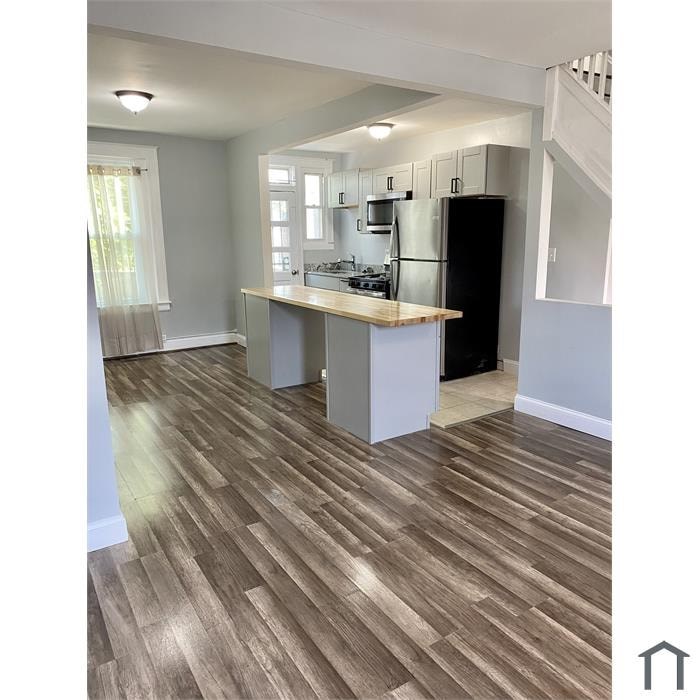 A kitchen with a wooden floor and white walls.