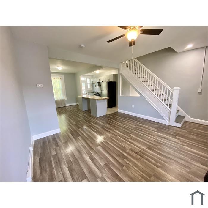 A room with a staircase and a ceiling fan.