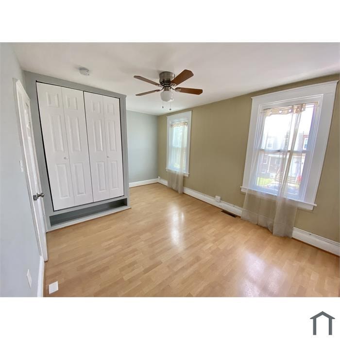 A room with a ceiling fan and a sliding door.