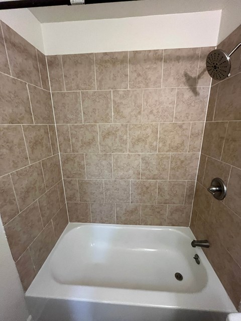 a small bathroom with a shower and a bath tub