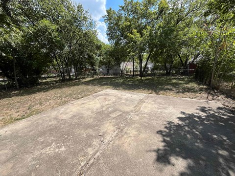 a large parking lot with trees on the side of it