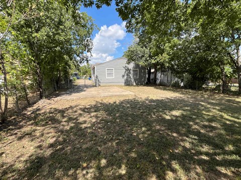 a blue house with a yard and trees