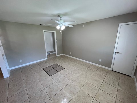 A room with a ceiling fan and tile flooring.