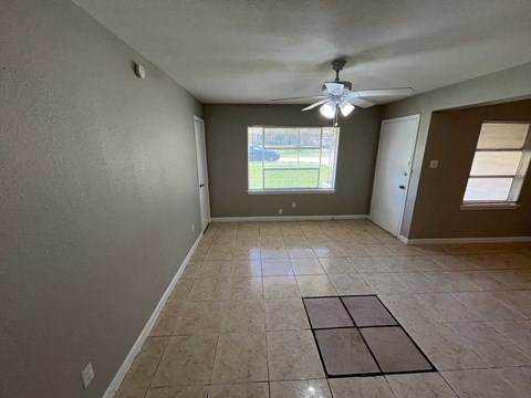 A room with a ceiling fan and a window.
