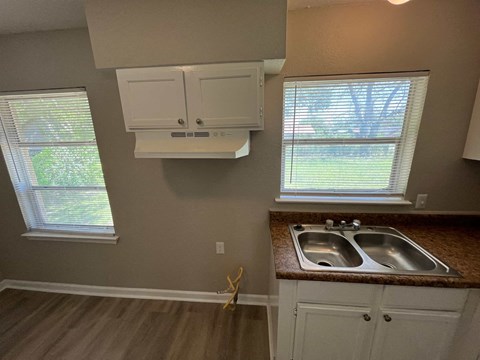 A kitchen with a double sink and a window.