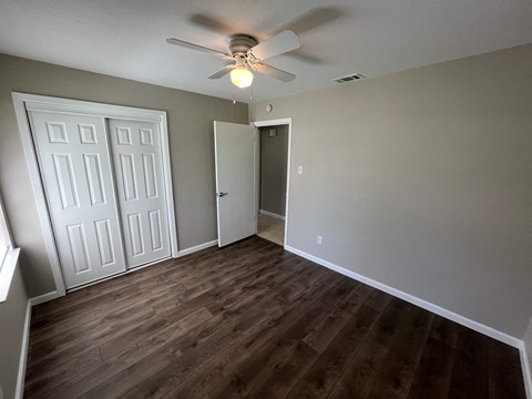 A room with a ceiling fan and a light fixture.