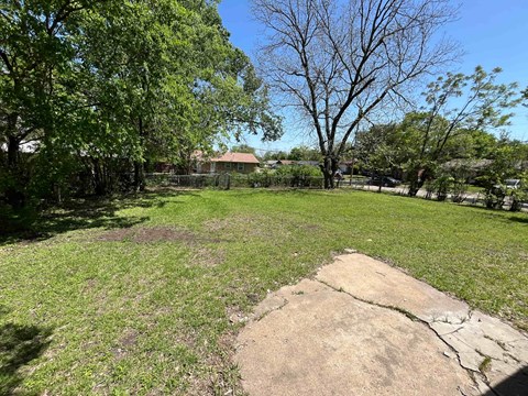 A large rock sits in the middle of a grassy field.