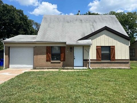 a brick house with a lawn in front of it