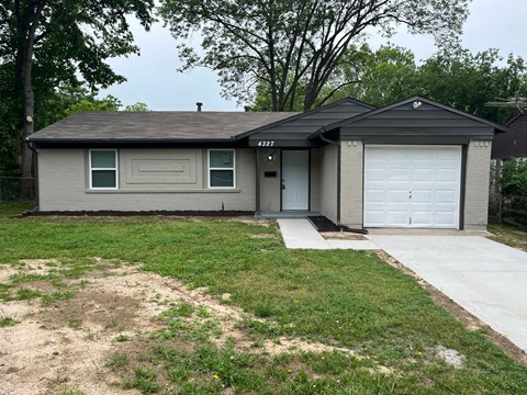 A house with a grey roof and a white garage door.