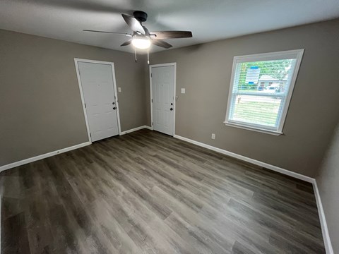 A room with a ceiling fan and a window.