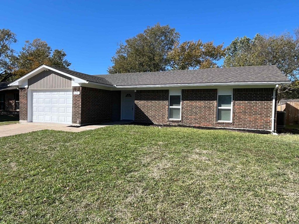 A house with a white garage door and a brick exterior.