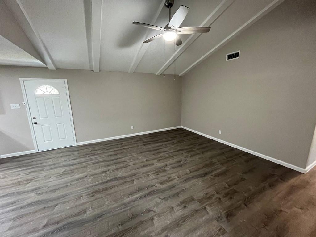 A room with a ceiling fan and a door.