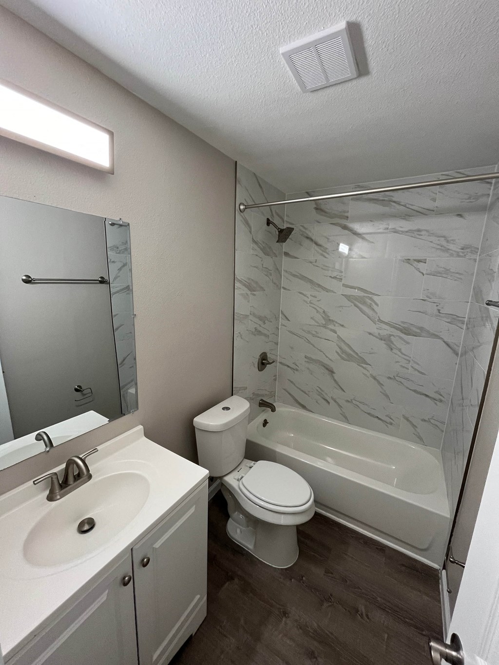 A bathroom with a toilet, sink, and bathtub.