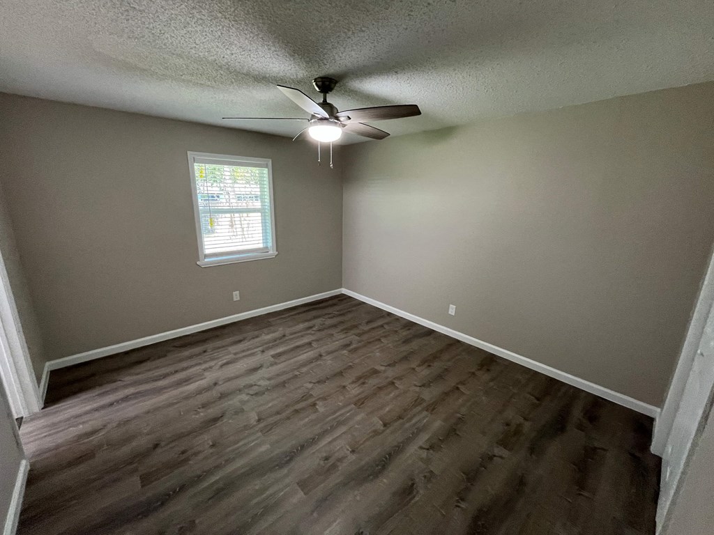 A room with a ceiling fan and a window.