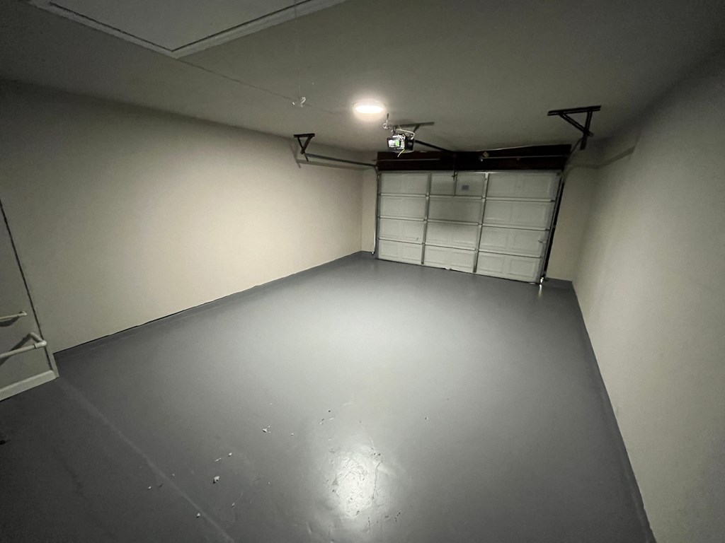 A spacious garage with a closed white door.