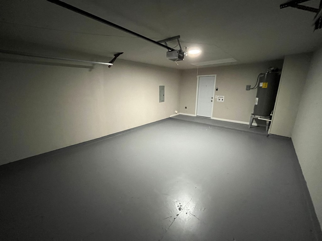 A spacious, empty room with a door and a light fixture on the ceiling.