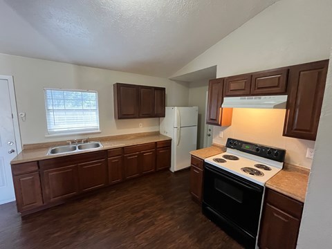 A kitchen with brown cabinets and a white fridge.