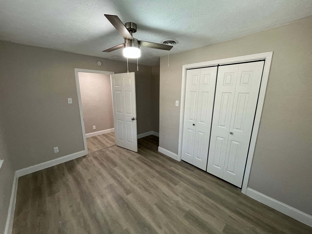 A room with a ceiling fan and two white doors.