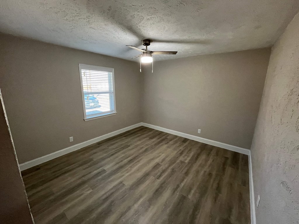 A room with a window and a ceiling fan.
