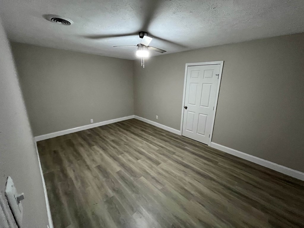 A room with a ceiling fan and a light fixture.