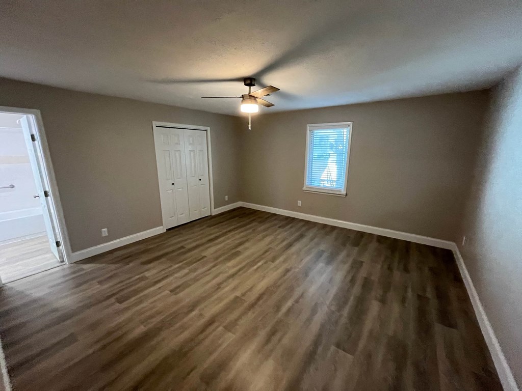 A room with wooden flooring and a ceiling fan.