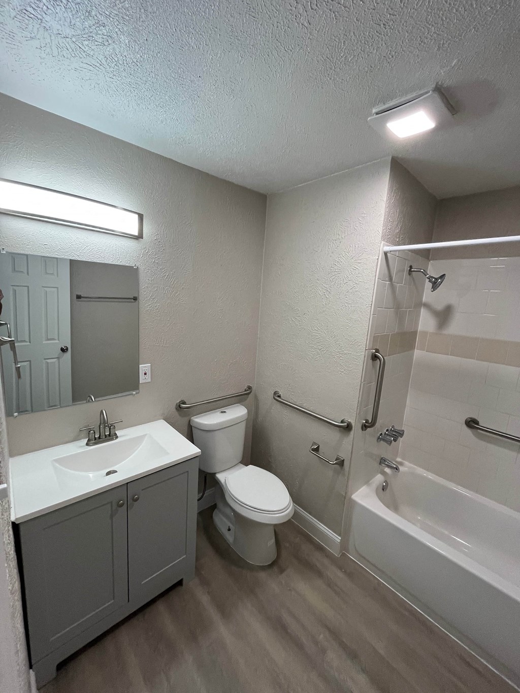 A bathroom with a sink, toilet, and bathtub.