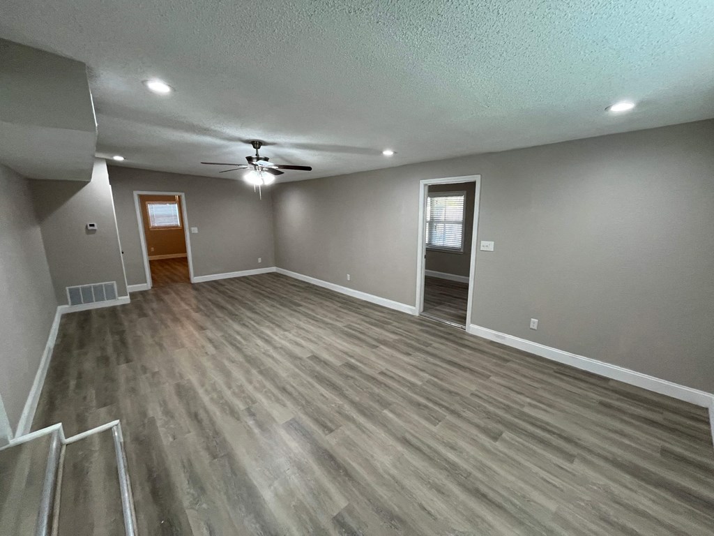 A room with a ceiling fan and lighting fixtures.