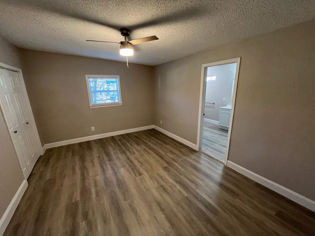 A room with a ceiling fan and a window.