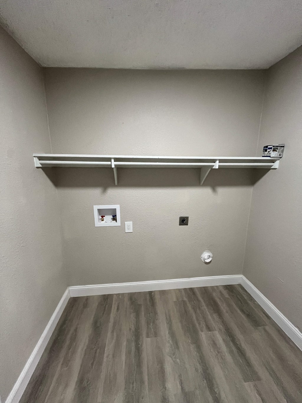 Empty room with a shelf and a picture frame on the wall.